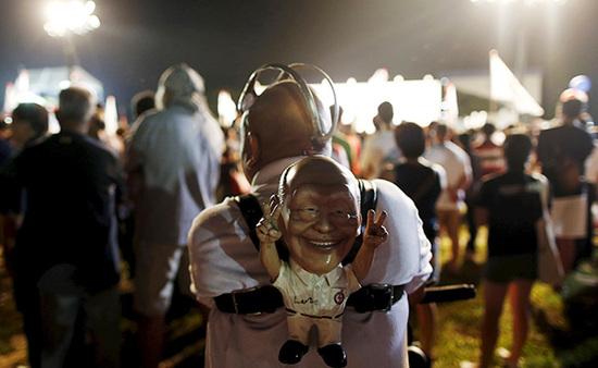 9月4日，新加坡，執(zhí)政黨的一場集會上，一名支持者背著一個李光耀的人偶。