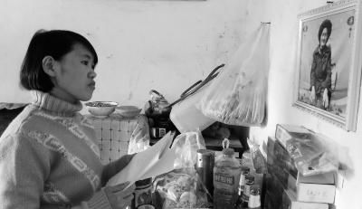 錢仁鳳站在母親遺像前。未能見母親最后一面是她的一大遺憾。