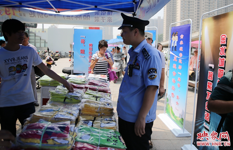 執(zhí)法人員勸導(dǎo)看守?cái)偽坏娜藛T搬離，停止非法占道經(jīng)營(yíng)。