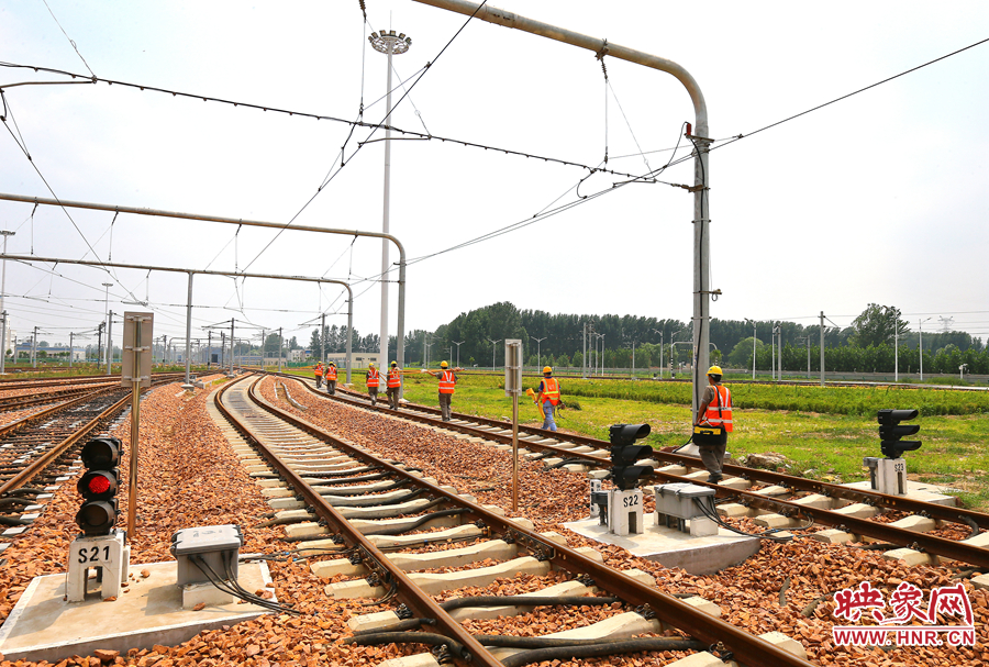 在太陽(yáng)的直射下，檢修工人扛著沉重的設(shè)備向施工地點(diǎn)出發(fā)