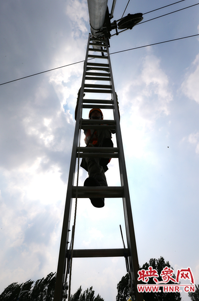 頂著太陽(yáng)的直射，檢修工不斷要爬上高處施工