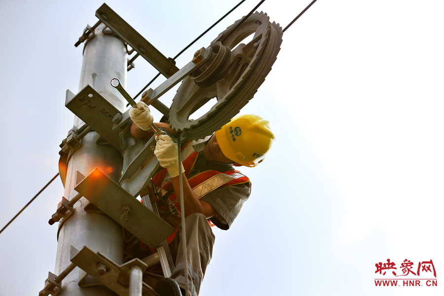被太陽(yáng)暴曬后的線(xiàn)桿碰著就能燙紅皮膚，可是檢修員此刻也顧不得許多