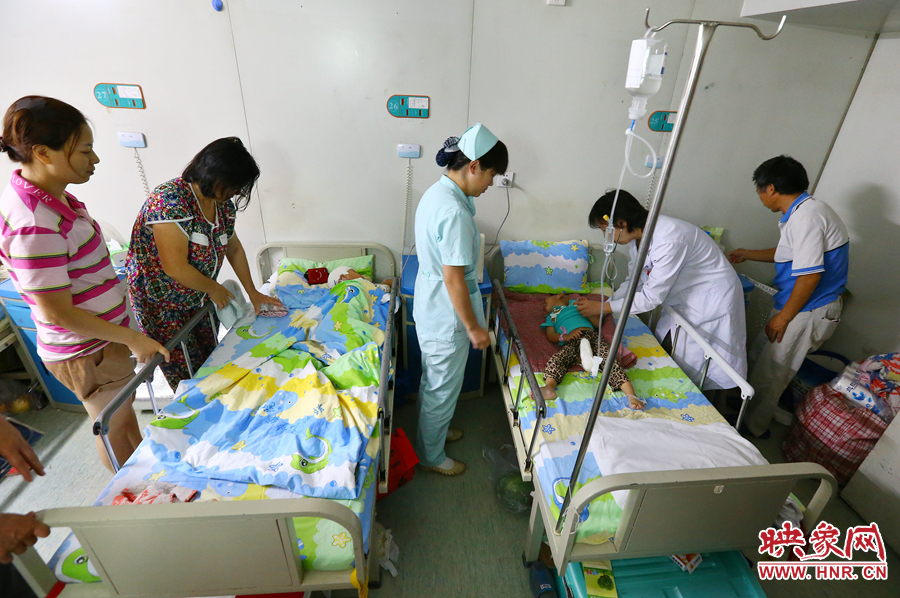 手術(shù)前，畫面右側(cè)的大龍正在接受醫(yī)生的檢查，左側(cè)的小龍還在熟睡。