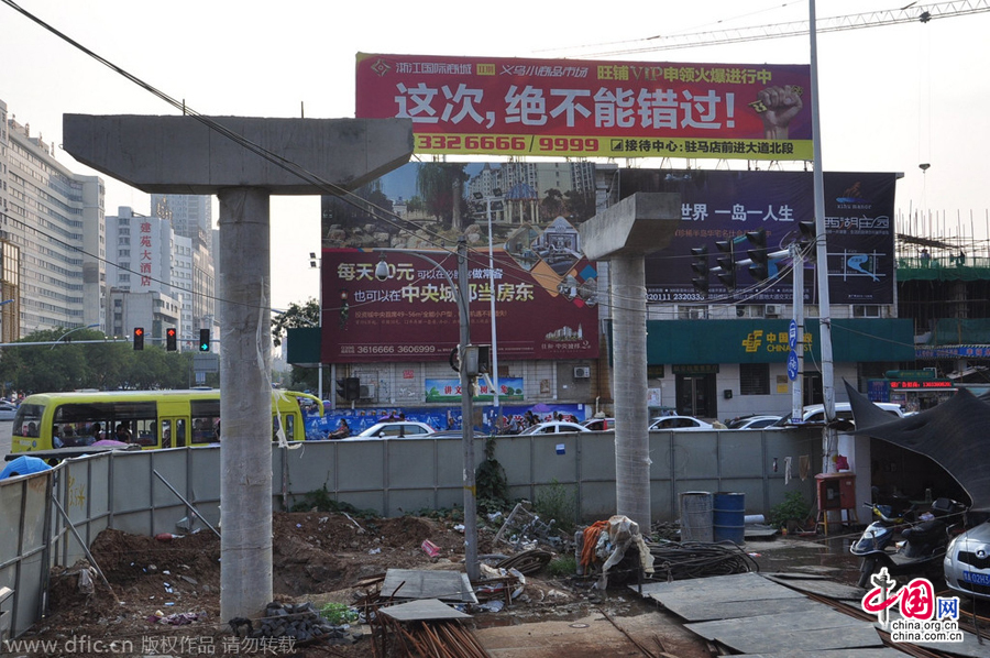 過街天橋一側(cè)的橋樁早已打好,可是對面的郵政銀行網(wǎng)點(diǎn)依舊在照常營業(yè)。