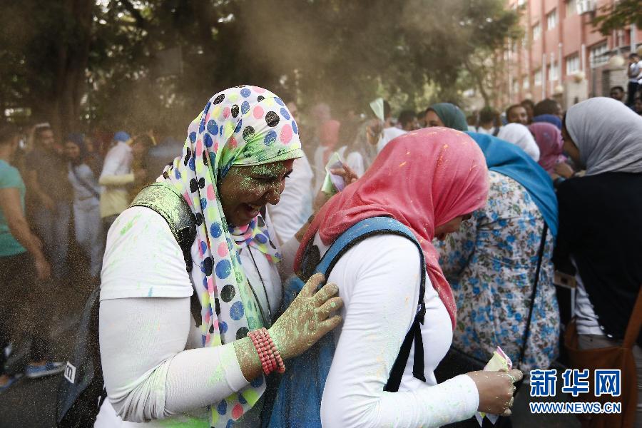 10月16日，在埃及首都開(kāi)羅，兩名女青年在“彩色跑”活動(dòng)中躲避人們拋撒的彩色粉末。