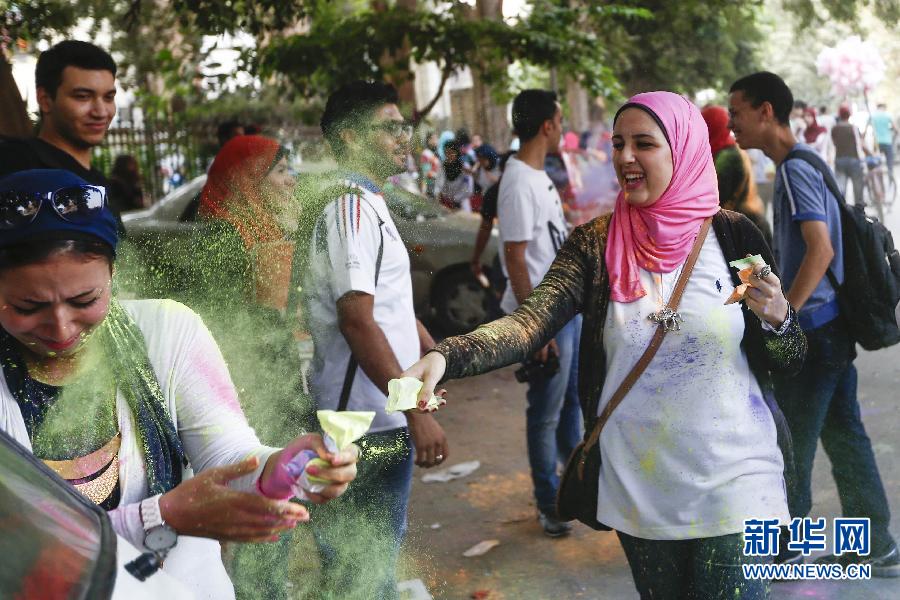 10月16日，在埃及首都開(kāi)羅，一名女青年在“彩色跑”活動(dòng)中拋撒彩色粉末。