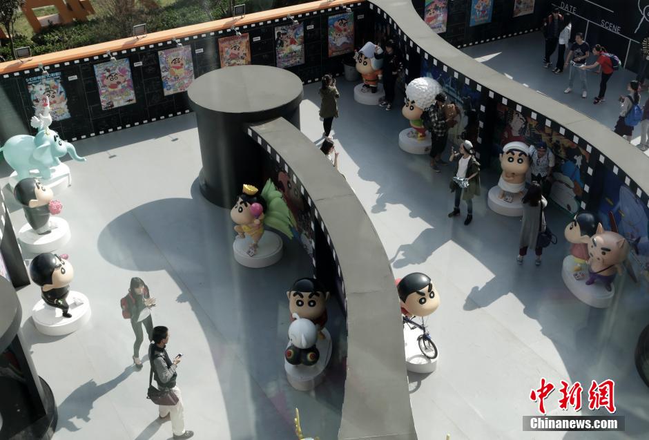 4月22日，游客與蠟筆小新合影?！跋灩P小新25周年紀(jì)念特展”日前在北京開(kāi)展，吸引了不少市民游客。