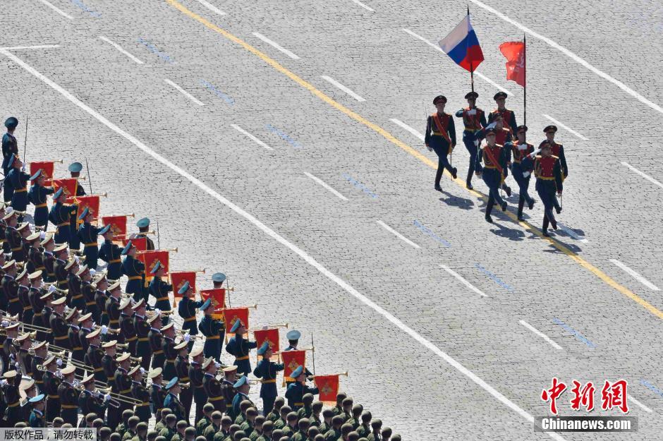 圖為俄羅斯國(guó)旗從受閱部隊(duì)前經(jīng)過(guò)。