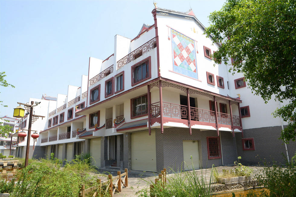 2016年7月26日，村民在廣西來賓市忻城縣隆達(dá)山水福城荒廢別墅間放牛。