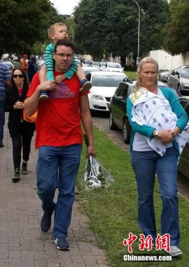 圖為一個白人家庭，由父母帶著孩子到曼德拉家門外悼念。中新社發(fā) 宋方燦 攝