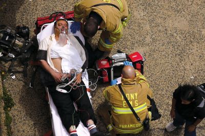 2日，救援人員在美國紐約地鐵事故車輛內(nèi)緊急疏散一名受傷乘客。圖/CFP