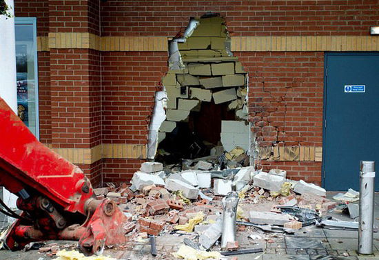 劫匪利用挖掘機(jī)的機(jī)械臂移走ATM機(jī)，留下滿地狼藉