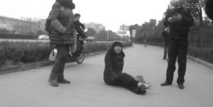 鄭大姐坐在地上，警方趕到進行施救。（視頻截圖由警方提供）