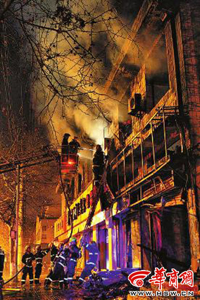 昨日22時(shí)10分，西安市豐慶路南小巷南口，消防官兵架梯子登上二樓施救 本組圖片由本報(bào)記者 閆文青 攝