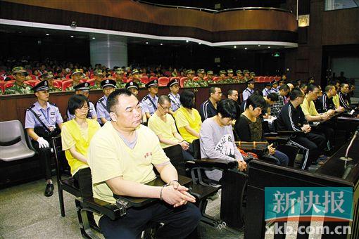 ■蔣洪偉(左一)等二十幾名被告被指控犯集資詐騙罪,昨日集體過(guò)堂?！　?鄭朝暉/攝