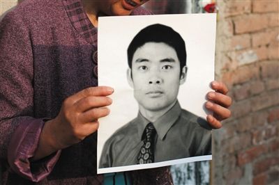 5月19日，朝陽北路，母親捧著張東文的遺像。新京報記者 侯少卿 攝