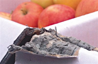 8月29日，新發(fā)地市場，一箱用“加重紙箱”包裝的蘋果正待售，紙箱夾層內(nèi)灰黑色的增重填充物清晰可見