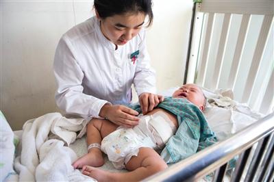 昨日，北京兒童醫(yī)院，護(hù)士為即將出院的被扎鋼針女嬰檢查傷口恢復(fù)情況。記者 高瑋 攝