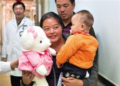 昨日上午，被扎針女嬰的母親抱著孩子和醫(yī)護(hù)人員送的玩偶準(zhǔn)備出院，院方稱孩子術(shù)后恢復(fù)良好。記者 高瑋 攝