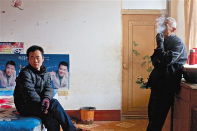 父親抽煙，兒子不語(yǔ)。逃跑的越南新娘，給袁迎賓父子帶來(lái)的是失落。新京報(bào)記者 周崗峰 攝