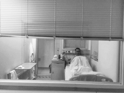 楊杰在醫(yī)院隔離病房中，沖記者揮了揮手。