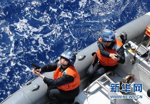 　3月28日，十余名臨檢拿捕隊員乘小艇駛至模擬可疑商船下方水面。