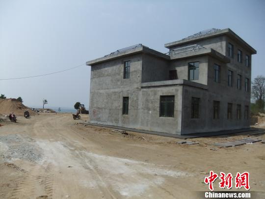 鴨河水庫庫區(qū)邊的新建別墅，一面墻上寫著“拆”，另一邊在加緊施工。吳揚　攝